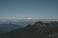 A panoramic view from a mountain summit, showing endless ridges fading into the horizon.