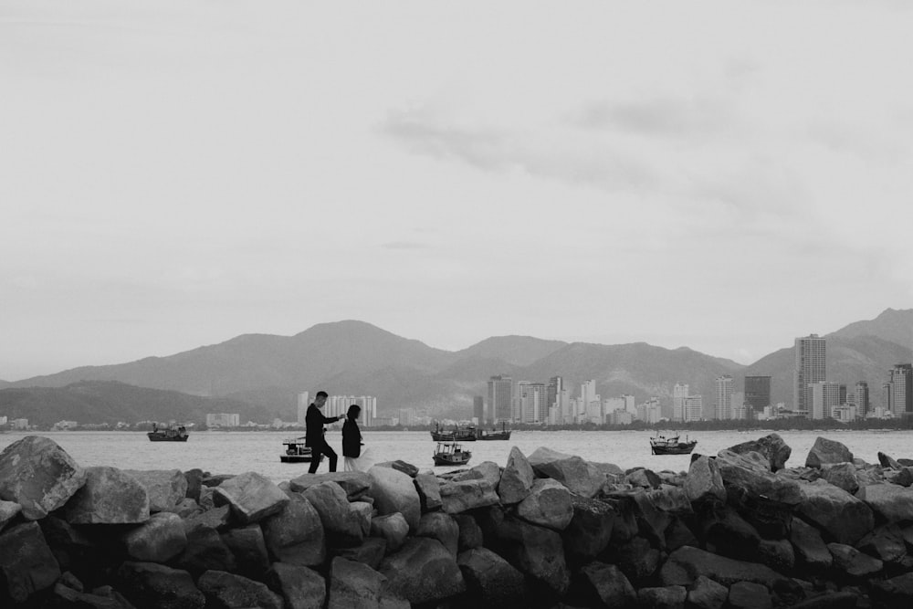 a couple standing on a rocky beach