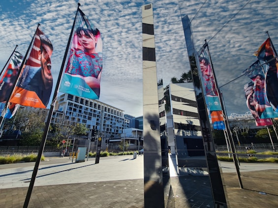 A bright, colorful flex print banner displayed outside a busy Dubai office building.