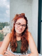a woman with red hair and glasses
