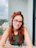a woman with red hair and glasses