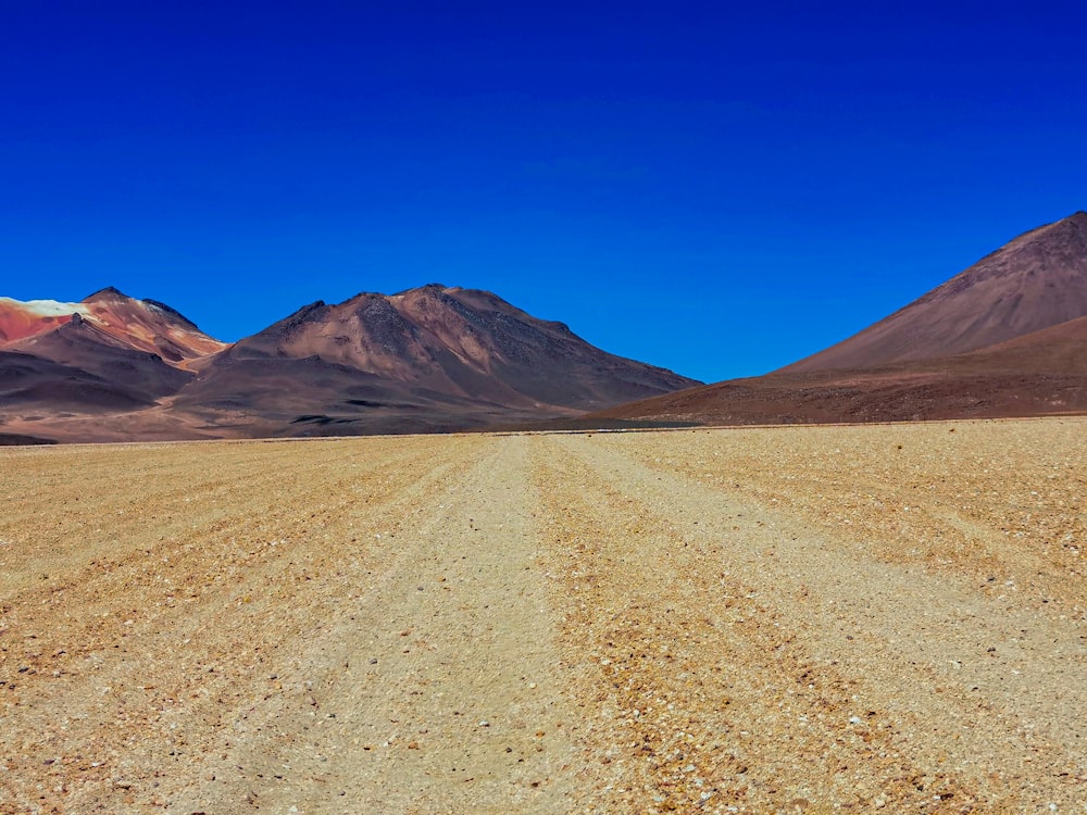 un paysage désertique avec des montagnes avec Laguna Verde en arrière-plan