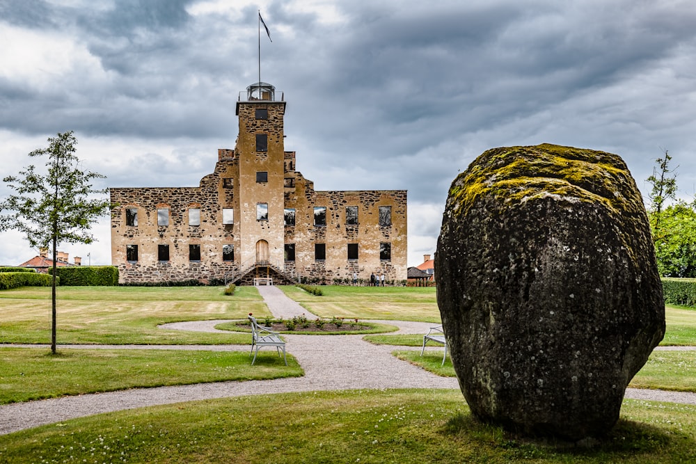 a large stone building with a large rock in front of it