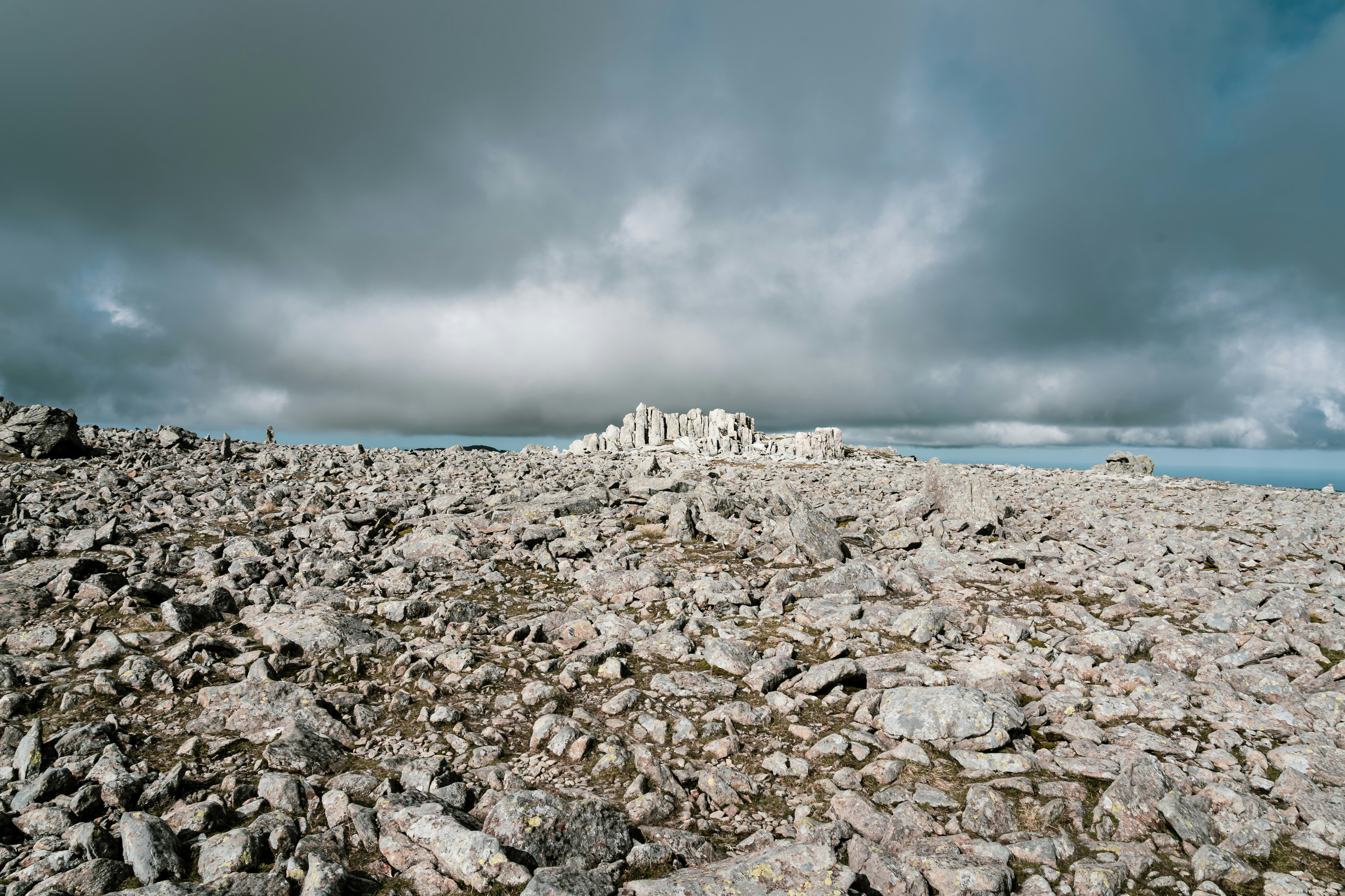a rocky beach with a large rock formation in the distance