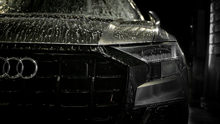 Close-up of a luxury car's glossy paint protected by 3m sari products under cinematic lighting