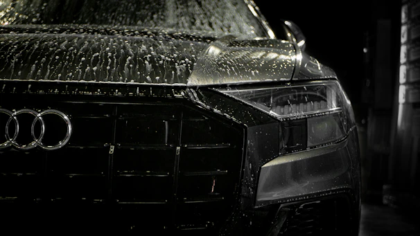 Close-up of water droplets sparkling on a freshly cleaned black sedan