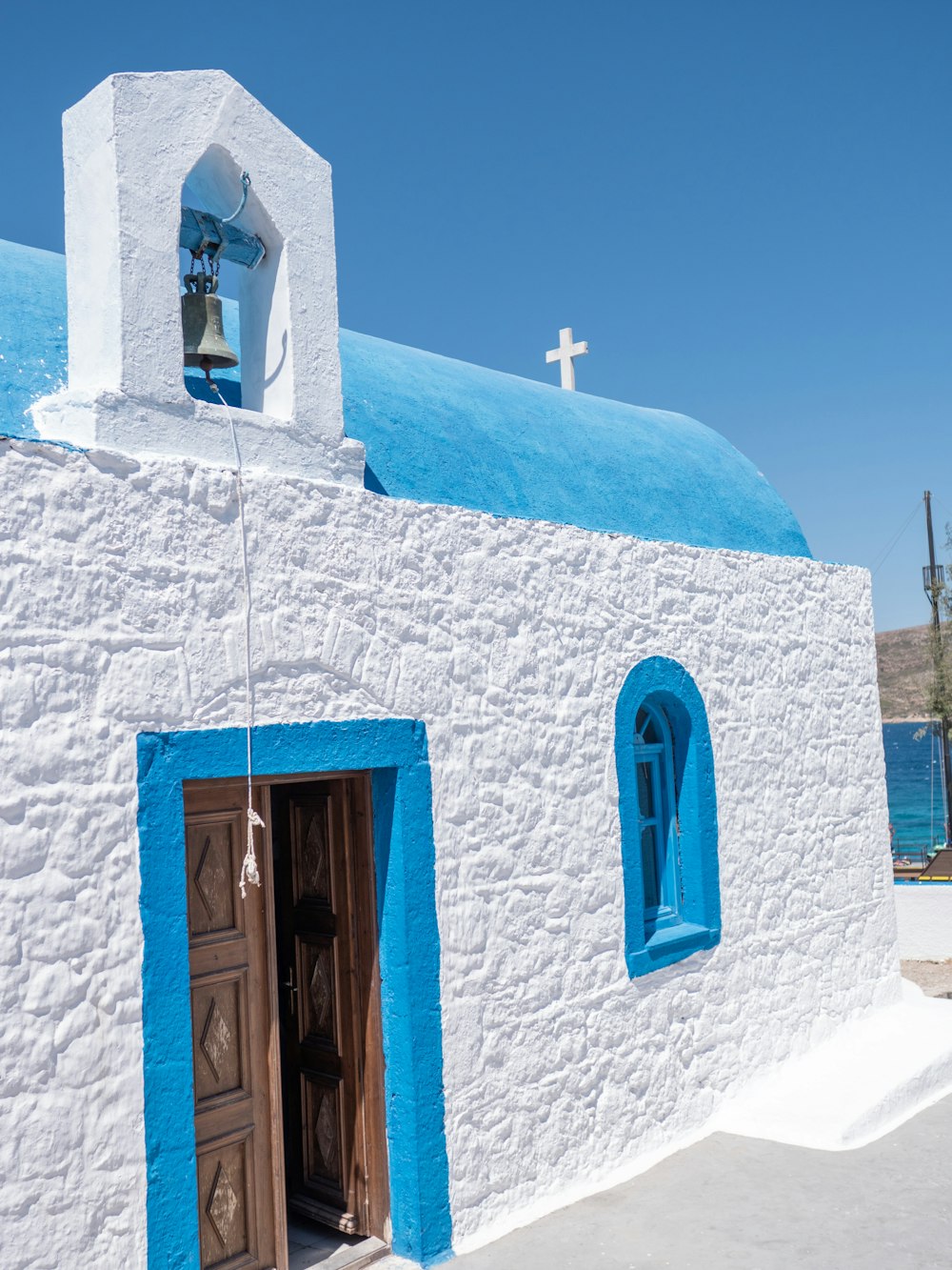 a white building with blue doors and a cross on top