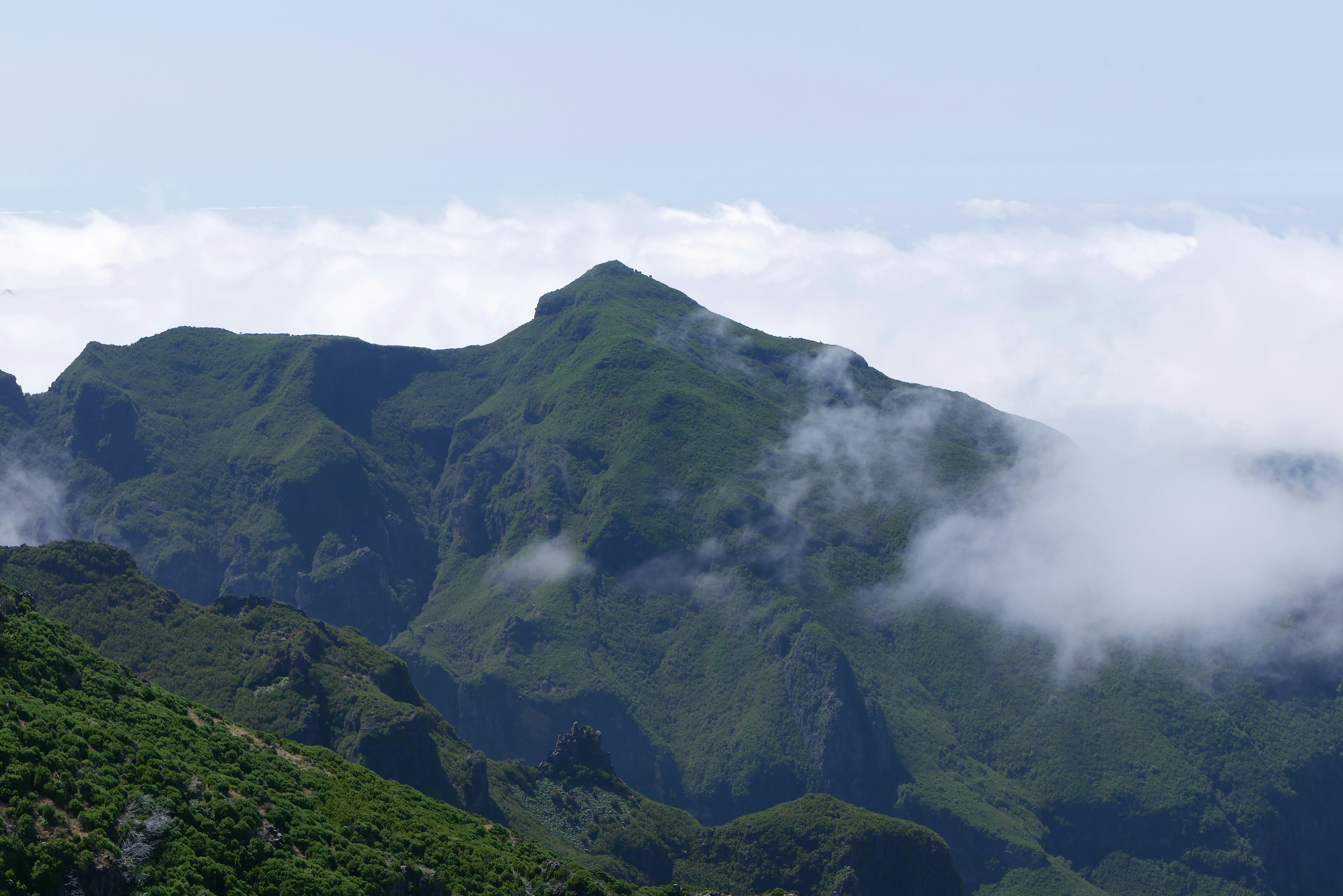 a mountain with clouds around it, 