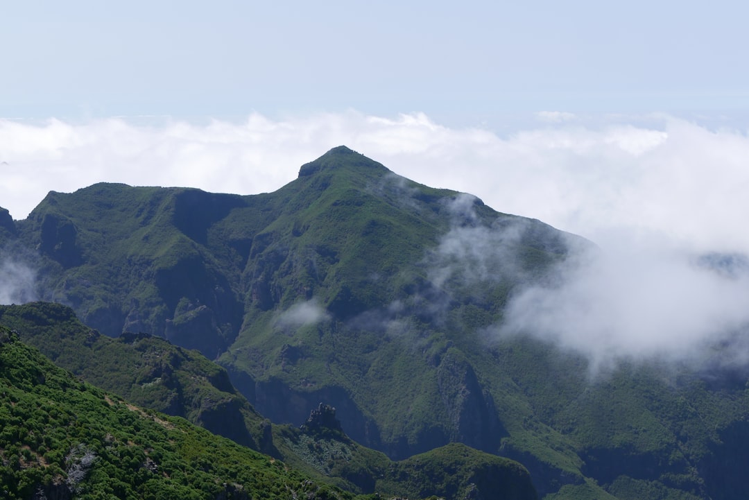 a mountain with clouds around it,