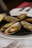 Close-up of a plate with stuffed mussels and şırdan, served in a warm, inviting Turkish eatery.