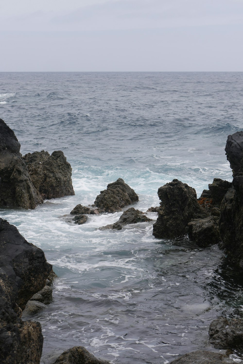 a rocky beach with waves crashing against it