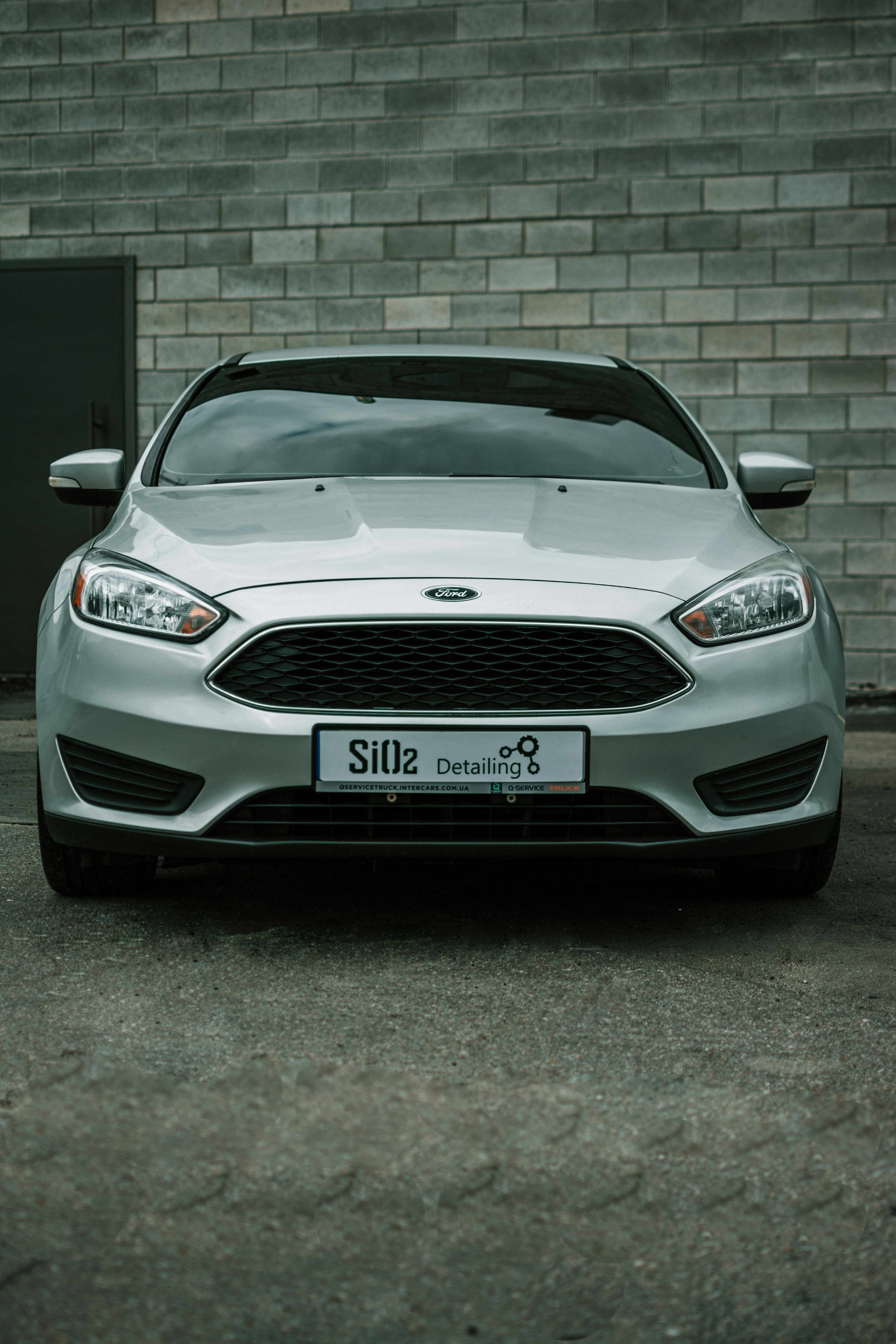 a car parked in front of a brick wall