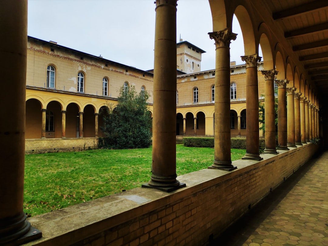 a building with pillars and grass,
