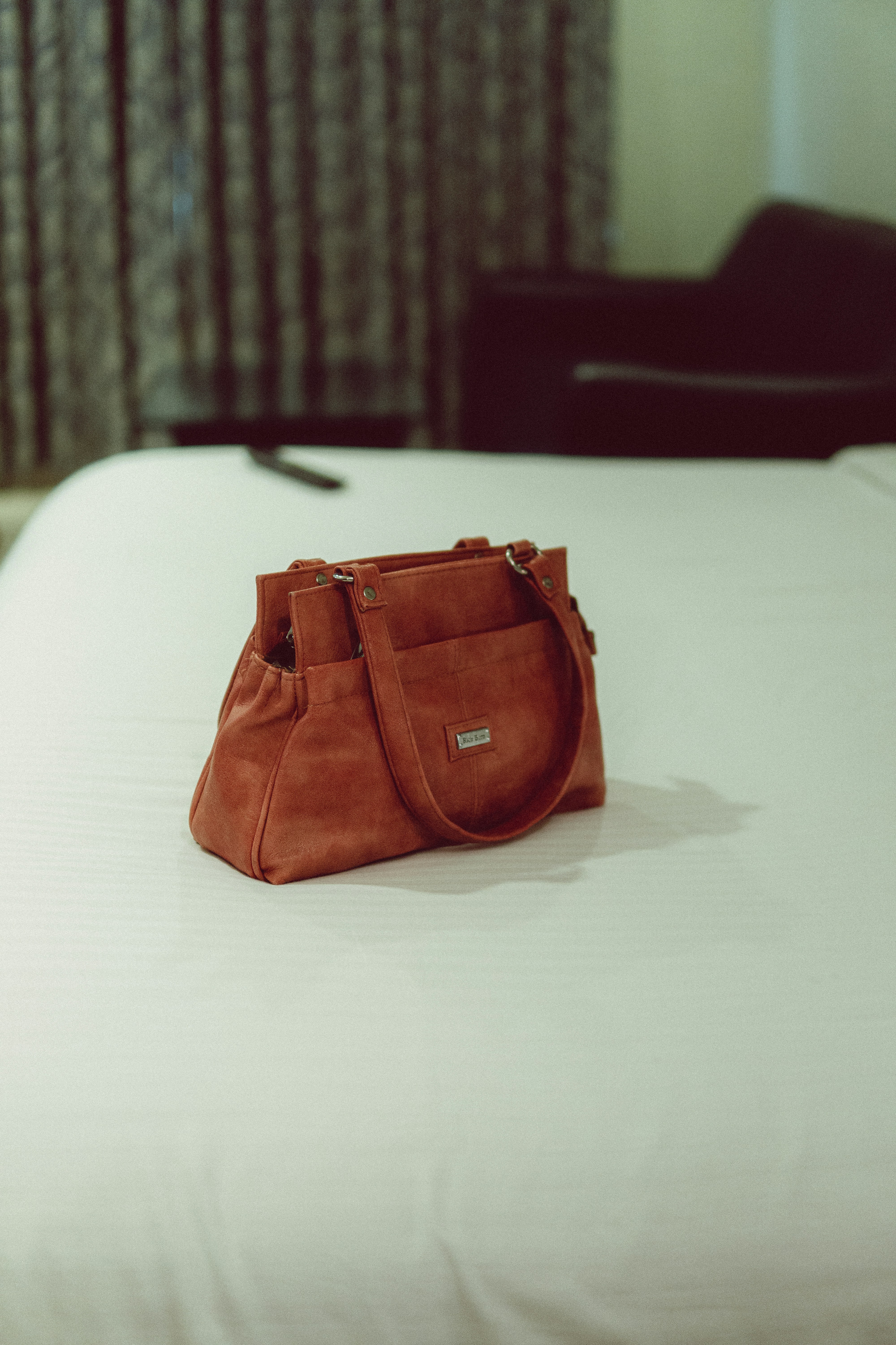 a brown leather purse on a white surface