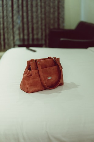 a brown leather purse on a white surface