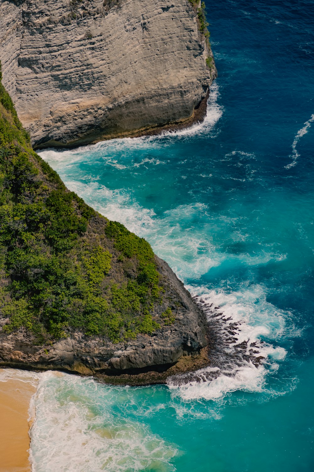 a rocky cliff next to a beach