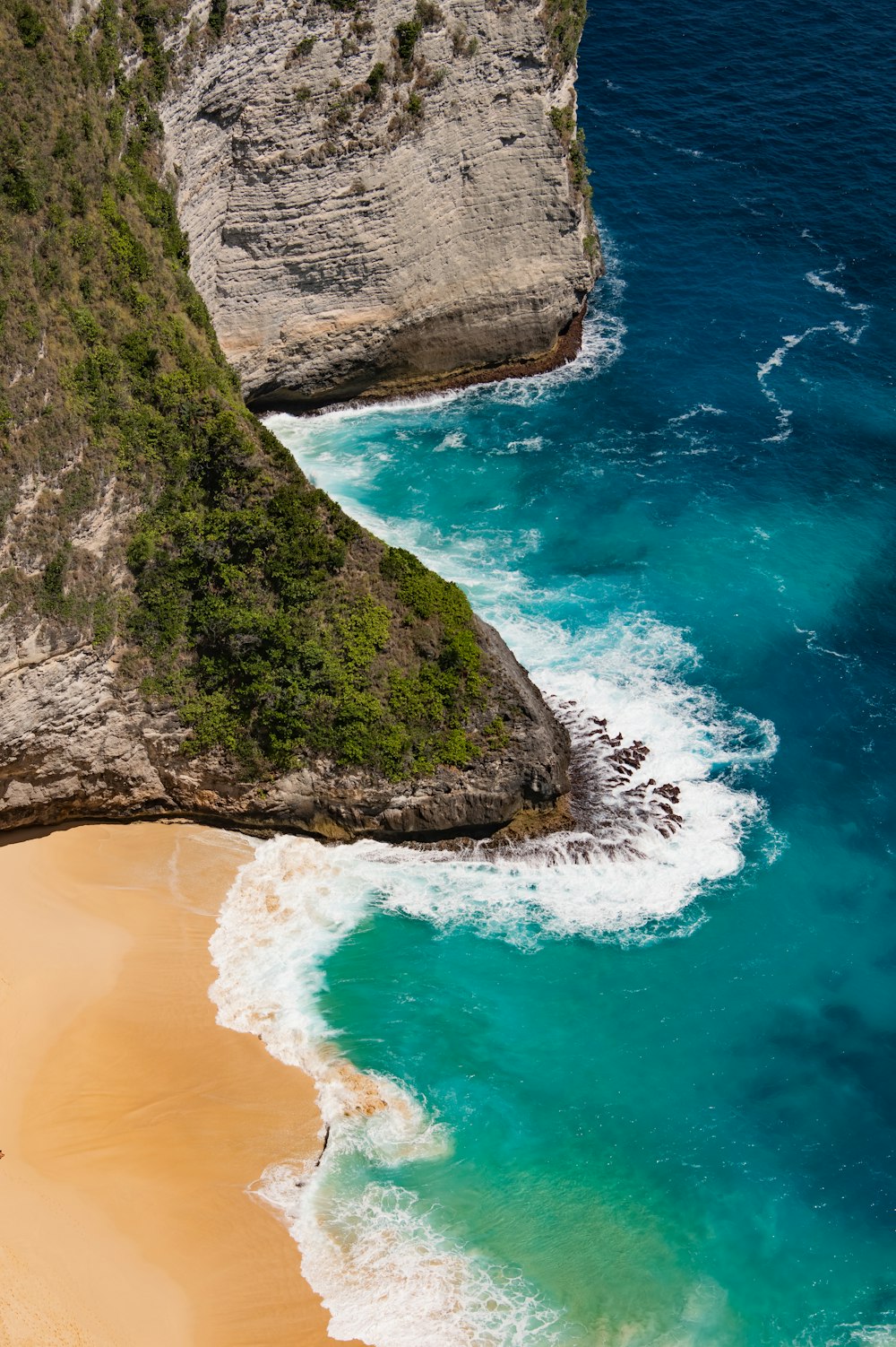 a beach with a cliff and water