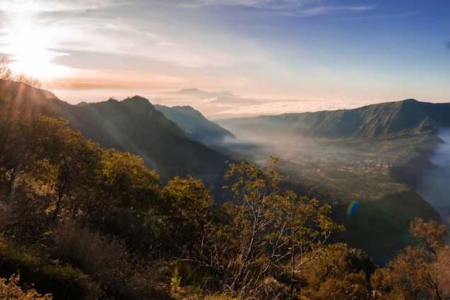 A serene sunrise over the rolling Appalachian Mountains in Northeast Tennessee, highlighting lush green valleys and misty peaks.