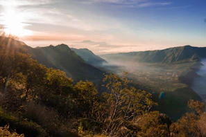 A vibrant sunrise over a lush green mountain trail, inviting adventure.