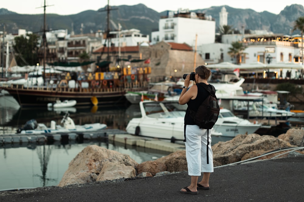 a person taking a picture of a marina with boats