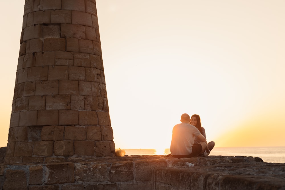 a couple sitting on a stone wall