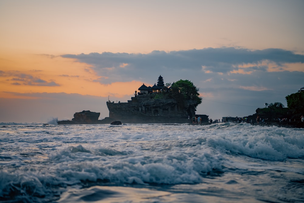 a body of water with Tanah Lot on the shore