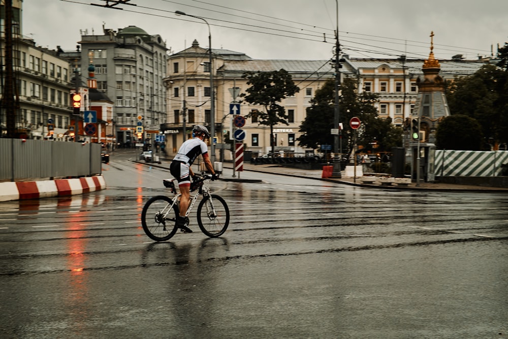 a person riding a bicycle on a wet street