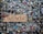 A collection of various padlocks attached to a wire mesh fence, with a wooden sign in the center inscribed with 'LOVE WINS'. The locks are of different shapes, sizes, and colors, some with names and messages written on them. The background is slightly blurred, emphasizing the locks and the sign.