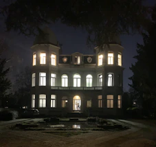 A striking modern mansion at dusk with bronze and gold accents glowing under cinematic lighting.