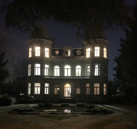 Elegant mansion exterior bathed in soft evening light, showcasing timeless architecture.