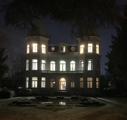 Chic villa exterior with manicured gardens and elegant lighting at dusk.