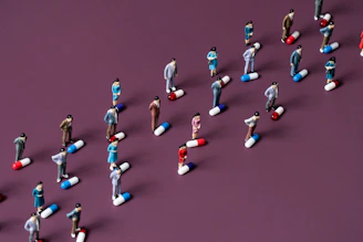 Top-down view of geeky miniature figures arranged on a textured gray surface.