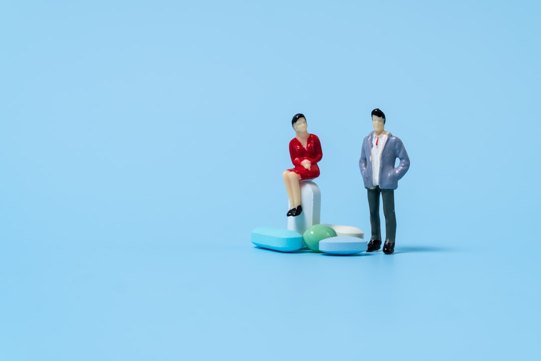 a man and a woman on a small model of a man, Miniature figures with pills.