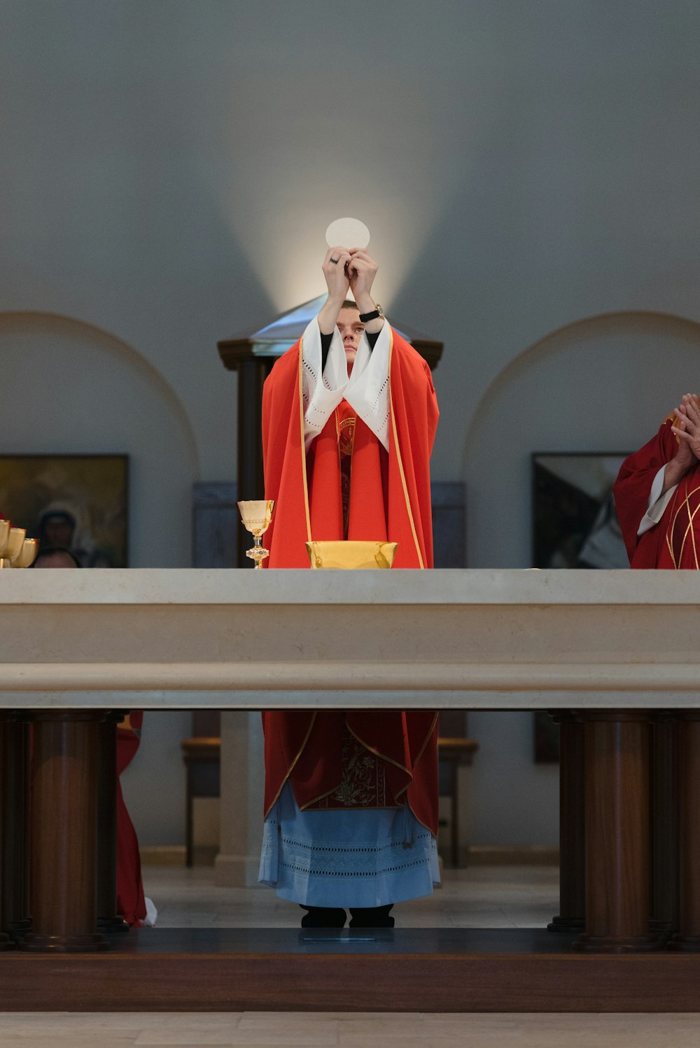 a person in a red robe and white hat standing at a podium