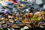 Colorful summer sandals displayed on a sandy beach backdrop.