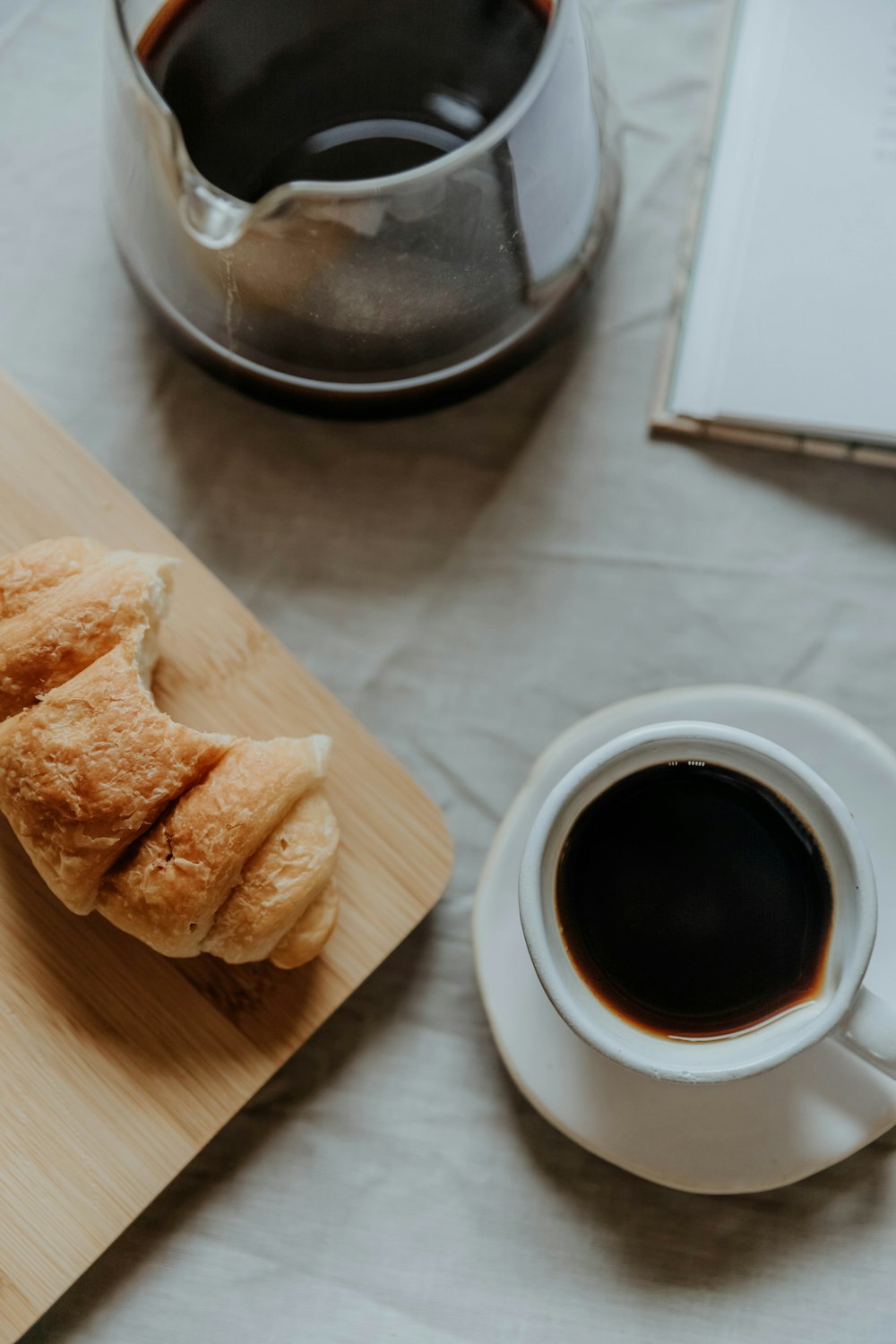 a cup of coffee next to a bagel and a bagel