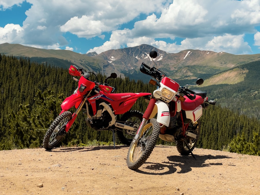 Two dual-sport motorcycles parked on a Colorado dirt ridge with Rocky Mountain peaks behind