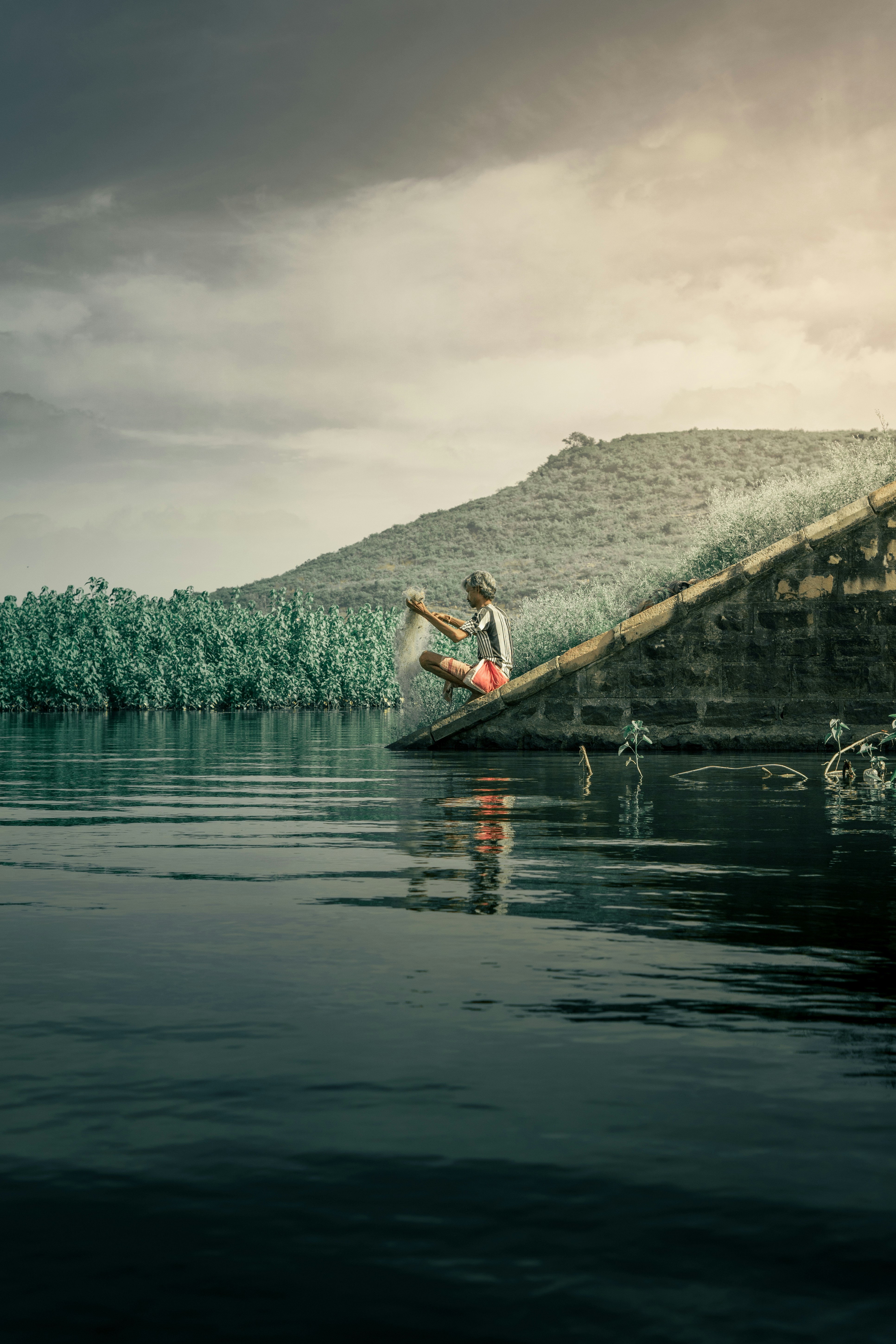 a person sitting on a rock in the water
