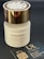 A white bottle of perfume labeled Andromeda by Tiziana Terenzi with a gold-colored cap. The bottle is accompanied by a black business card for UR Perfume, featuring QR codes and social media handles.