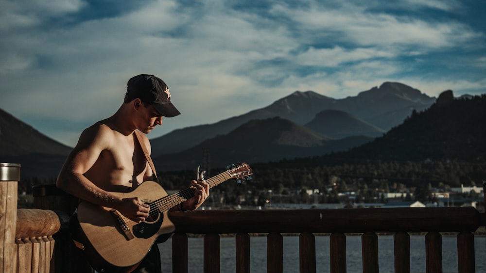 a person playing a guitar on a pier