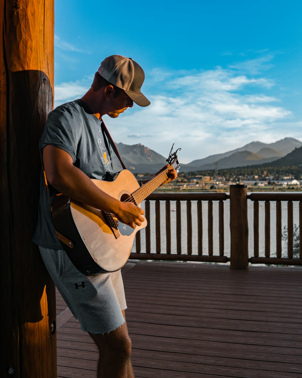 a man playing a guitar on a deck