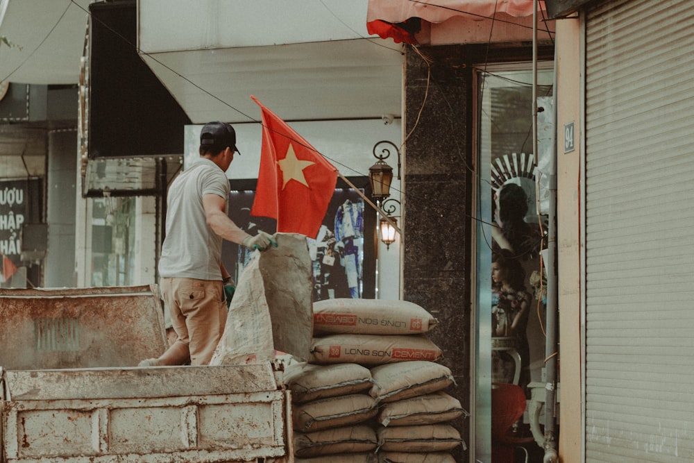 a man standing next to a stack of bread