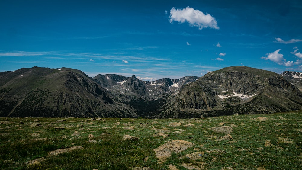 a grassy area with mountains in the background