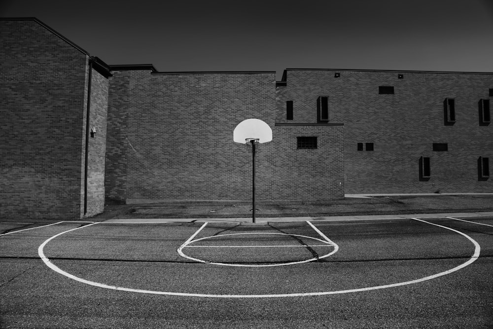 レンガ造りの建物の前のバスケットボールコート