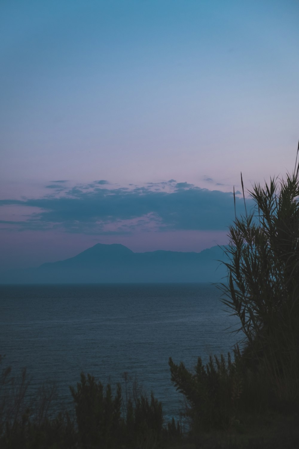 a body of water with a mountain in the distance