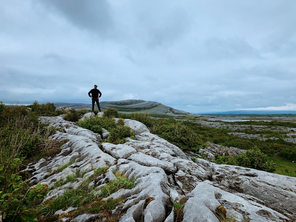 a person standing on a rocky hill