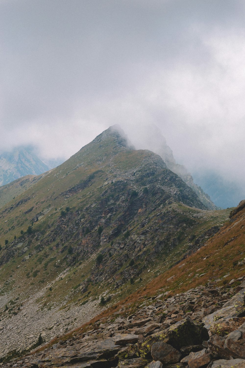 a rocky mountain with a foggy sky