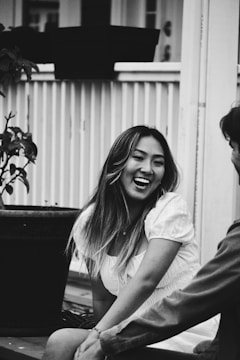 A friendly companion sharing a laugh with an elderly woman on a porch swing.