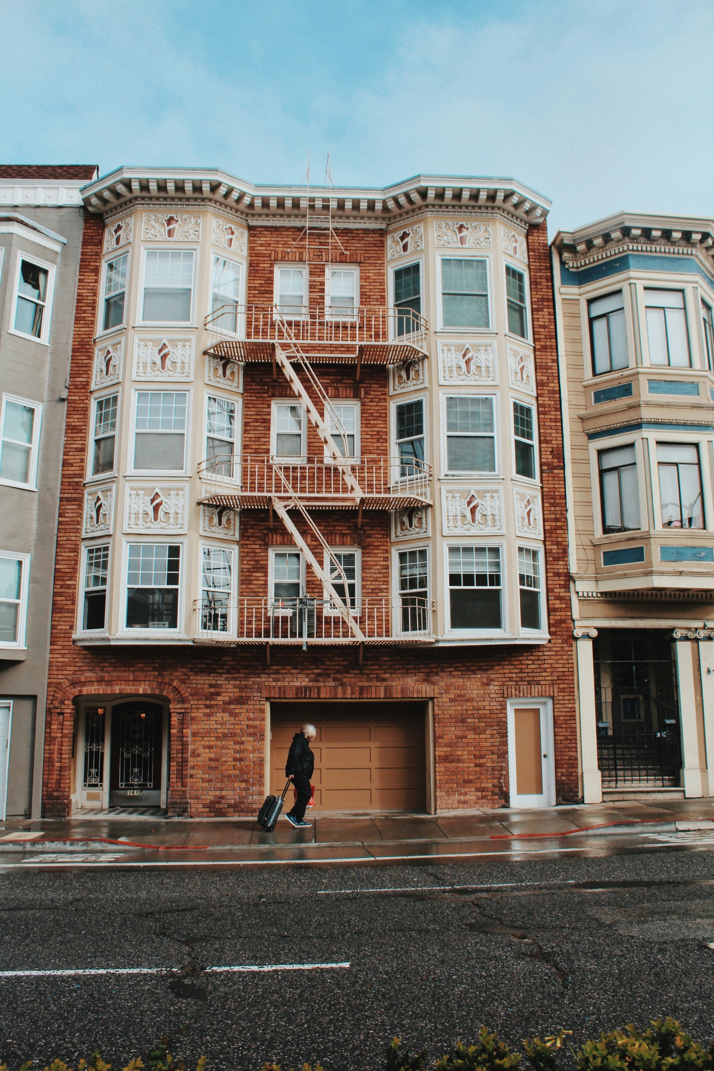 a person walking on the sidewalk with St. James Hotel in the background
