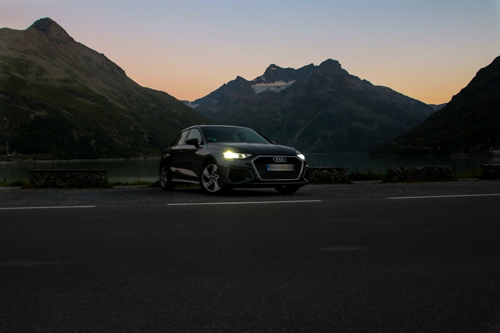 a car parked on a road with mountains in the background